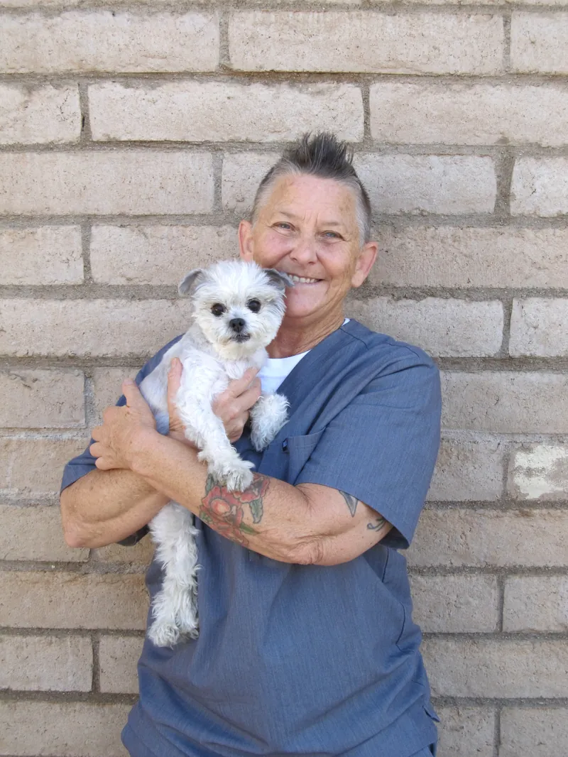 Angie, Veterinary Assistant, holding a small white dog